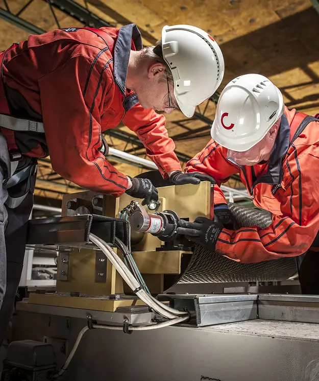 Industrial technicians servicing specialized mechanical equipment