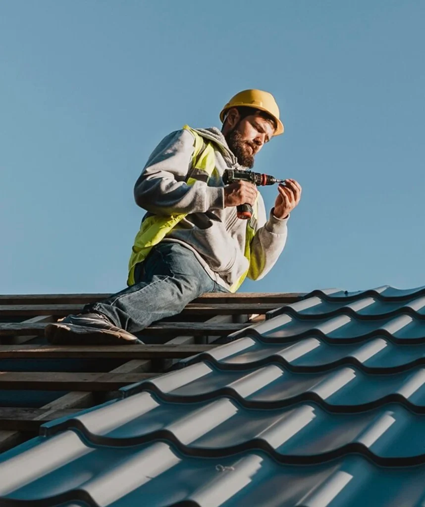 Professional roofer installing metal roofing on a residential building